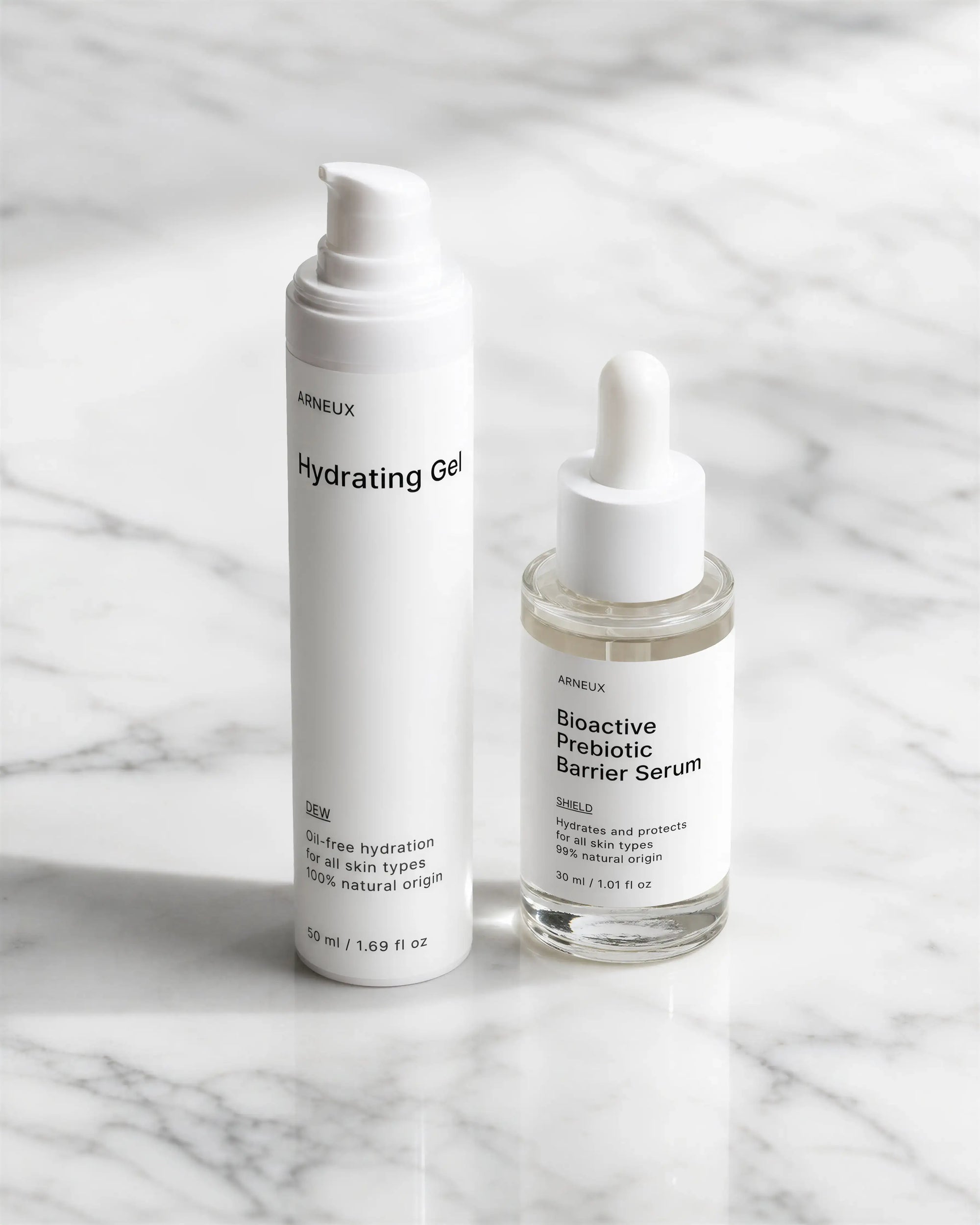 Arneux pump bottle DEW and glass serum dropper SHIELD on white marble, ECOCERT COSMOS certified no parabens no silicones