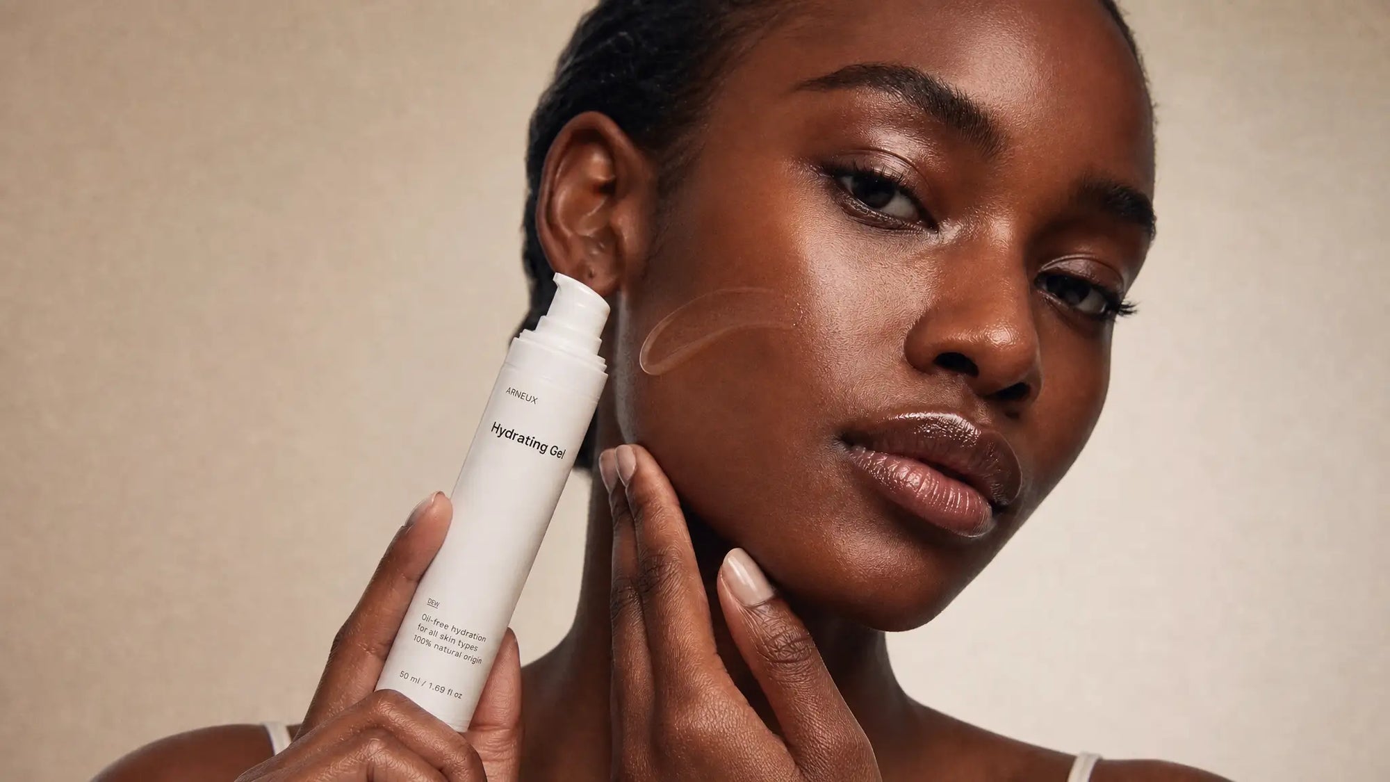 Woman applying Arneux DEW hydrating gel to cheek, European cosmetics standards 100% natural origin formula