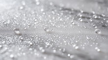 Fine keratin hair mist spray droplets scattered on silver surface, weightless mist formula texture