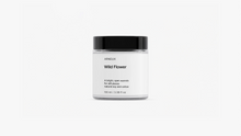 ARNEUX Wild Flower travel candle glass jar with black lid, light floral soy wax candle front view on grey background