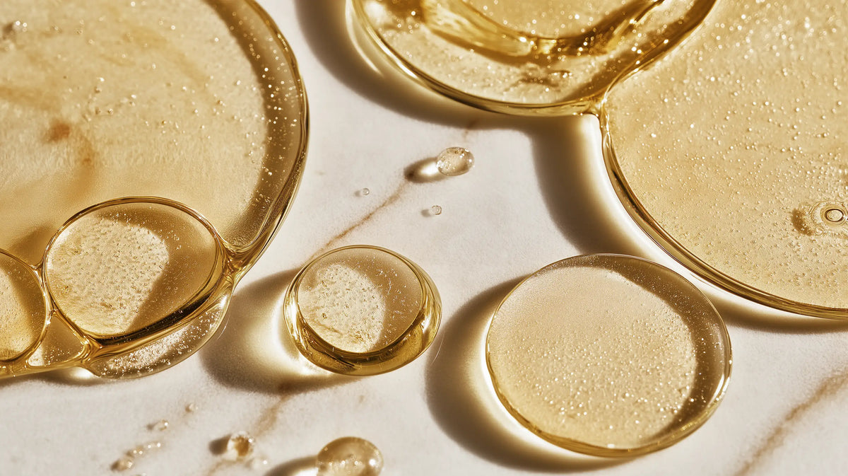 Golden oil phase swirling on marble surface, showing DISSOLVE biphasic remover oil-water formula