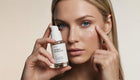 Woman dispensing LIFT caffeine gel booster, clear gel drop rubbing into under eye