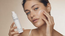 Woman pressing NIGHT nourishing rich cream into cheek with fingertips, plump moisturized skin
