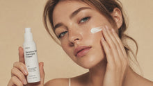 Woman smoothing REST sensitive skin overnight cream into cheek with fingertips, calm skin close-up