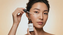Woman dispensing LIFT caffeine gel booster from dropper bottle, clear gel drop falling to cheekbone