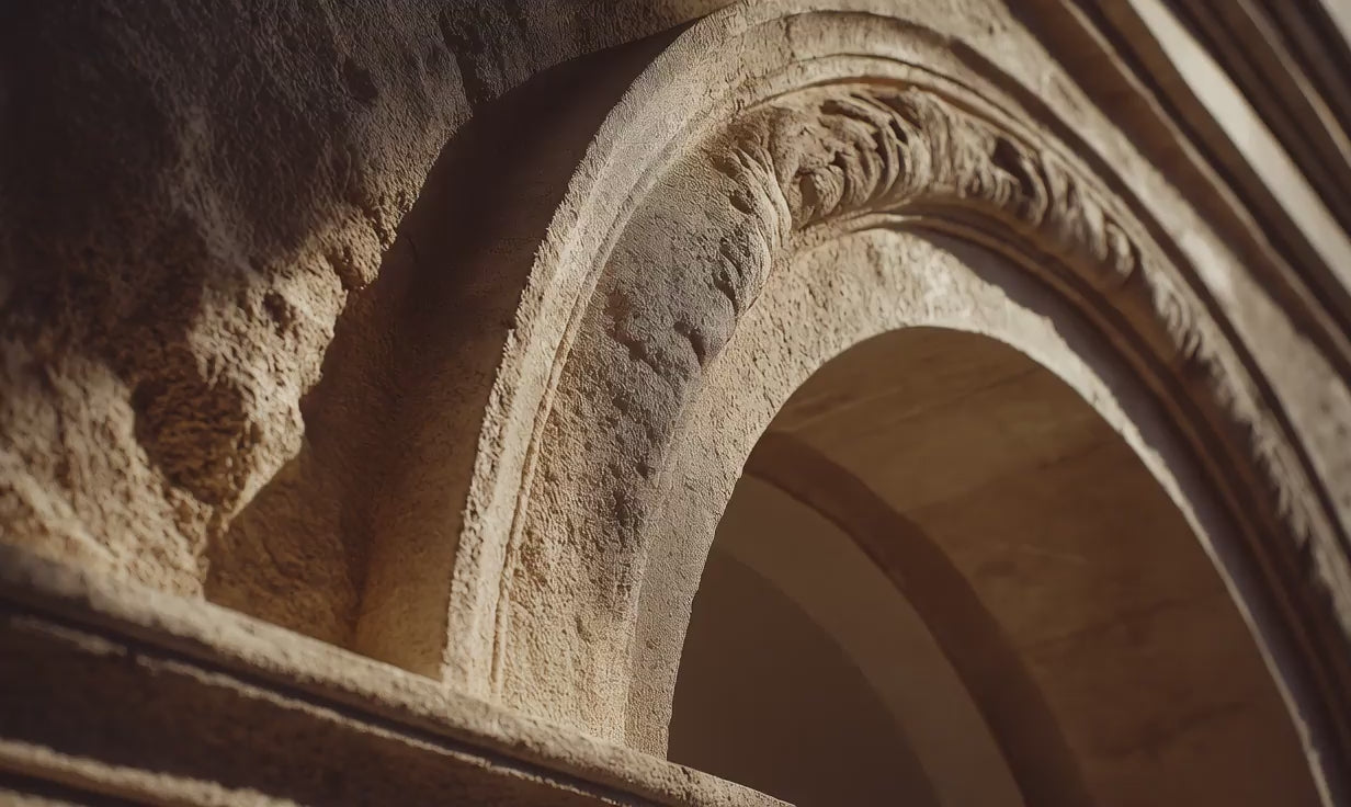 Ornate European limestone archway close-up, Arneux brand story founded in France EU-made heritage