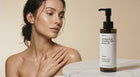 Woman with radiant glowing neck and decolletage skin holding NOURISH omega 6-9 body oil bottle