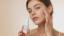 Woman dotting CORRECT dark spot care onto cheekbone with precision applicator, targeted spot treatment