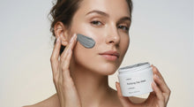 Woman smoothing FLAWLESS purifying clay mask across face with fingertips, jar held in hand