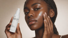 Woman pressing CALM blemish moisturizer into cheek with fingertips, clear skin close-up view