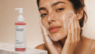 Woman massaging CLEANSE radiant glow facial wash foam across face, gentle no-strip morning cleanse