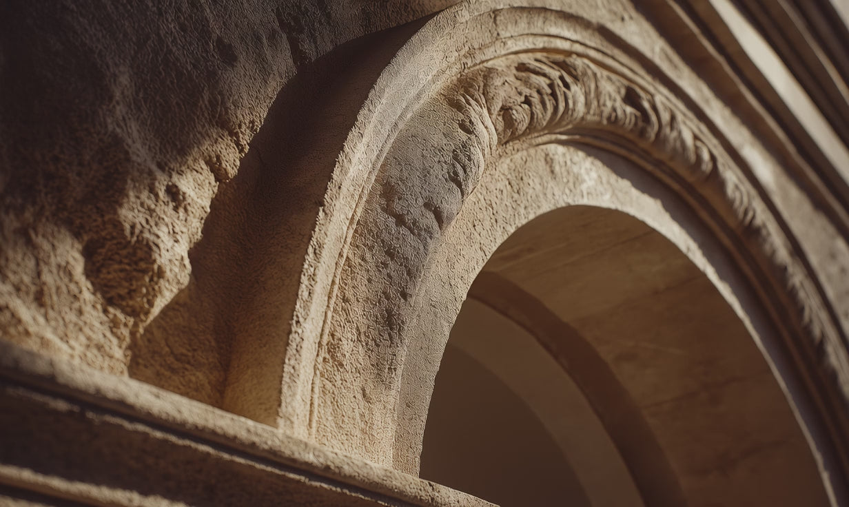 Ornate European limestone archway close-up, Arneux brand story founded in France EU-made heritage